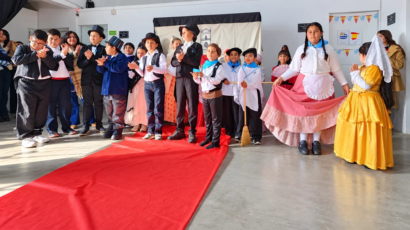Alumnos vestidos de gauchos y damas antiguas, en un acto