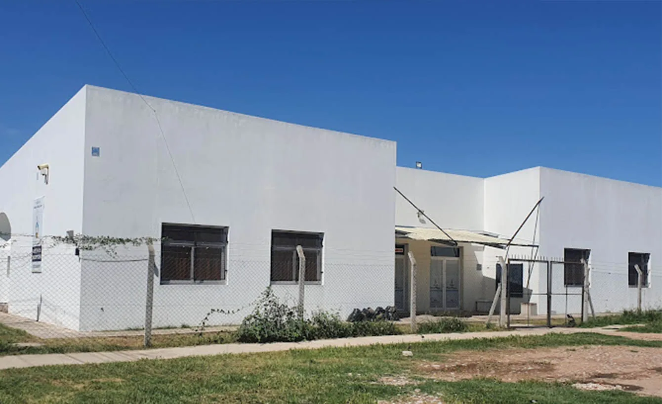 El frente de la escuela desde la calle, con el cielo despejado